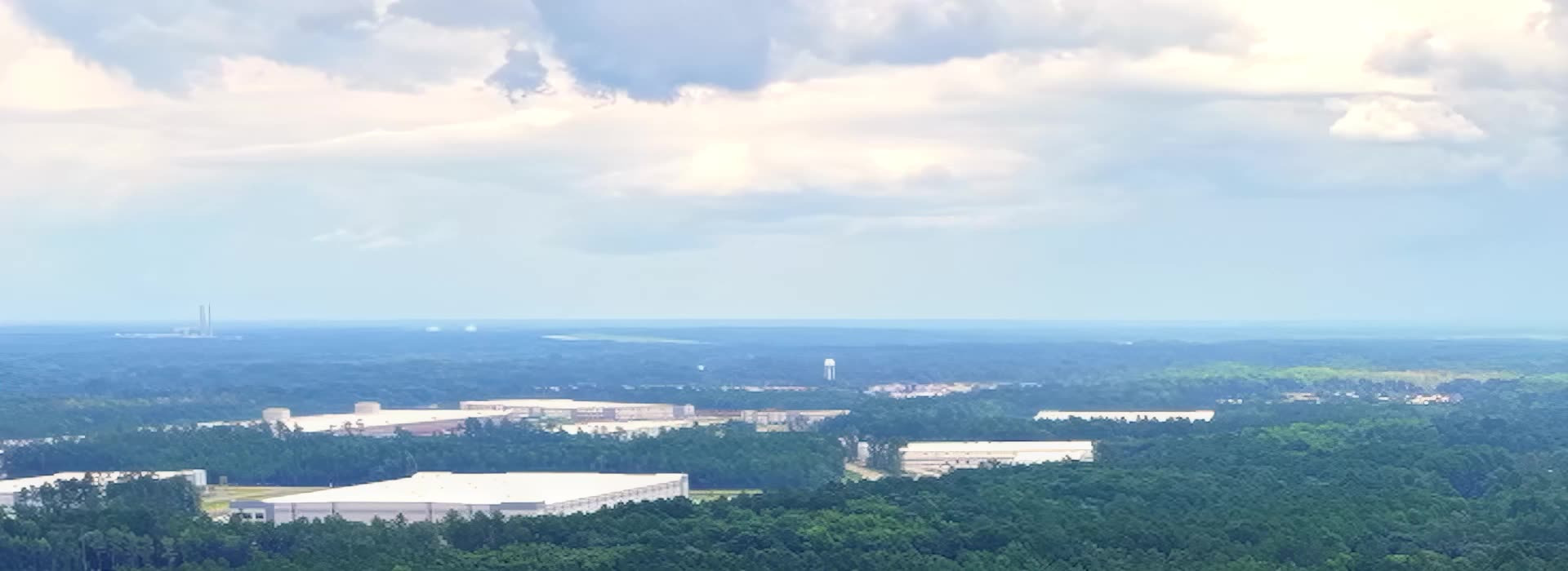 Aerial view across Effingham County forest toward nearby industry.